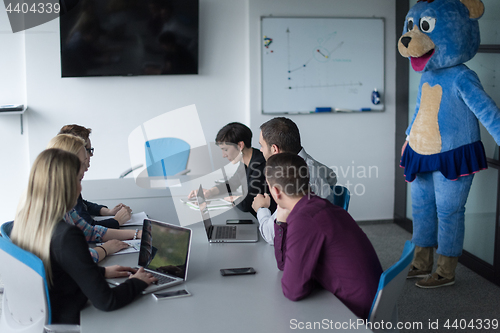 Image of boss dresed as bear having fun with business people in trendy of