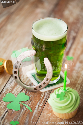 Image of glass of beer, cupcake, horseshoe and gold coins