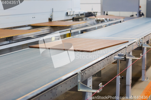 Image of chipboards on conveyer at furniture factory