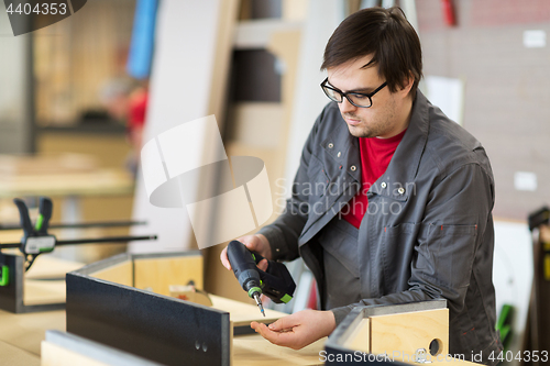 Image of assembler with screwdriver making furniture