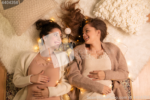 Image of happy female friends in pajamas at home