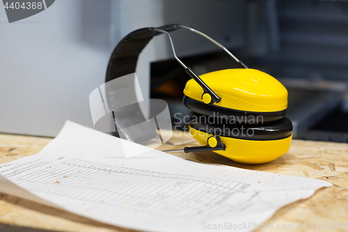 Image of industrial earmuffs and bill on table at workshop