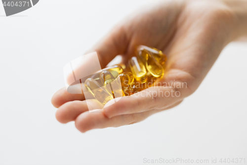 Image of hand holding cod liver oil capsules