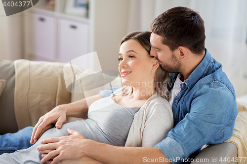 Image of man hugging pregnant woman at home