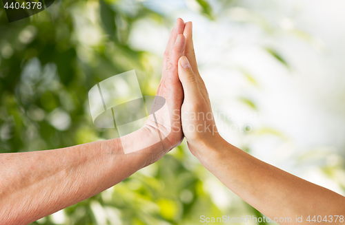 Image of close up of senior and young woman hands touch