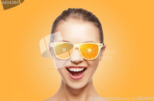 Image of happy teenage girl in sunglasses with oranges