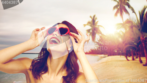 Image of woman with red lipstick and heart shaped shades