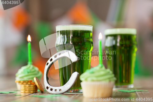 Image of glass of beer, cupcakes, horseshoe and gold coins