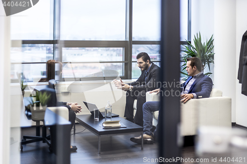 Image of Business people sitting at working meeting in modern corporate office.