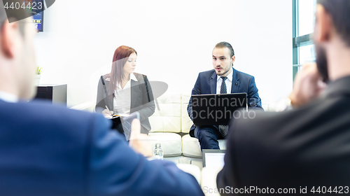 Image of Business people sitting at working meeting in modern corporate office.