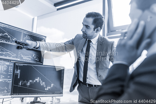 Image of Stock brokers trading online in corporate office.