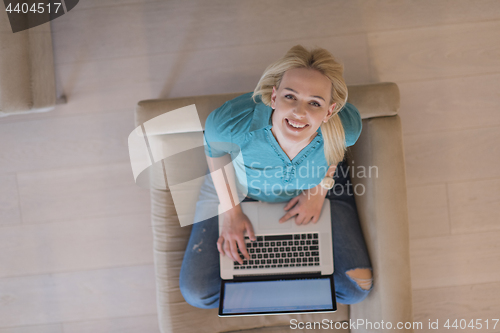 Image of Young woman using laptop at home top view