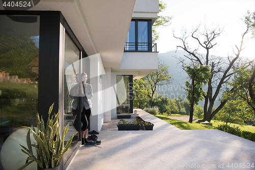 Image of woman in front of her luxury home villa