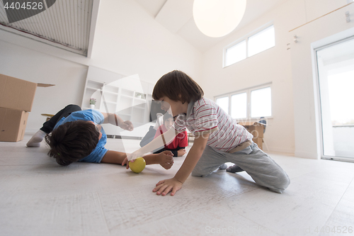 Image of boys having fun with an apple on the floor