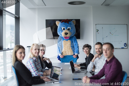 Image of boss dresed as bear having fun with business people in trendy of