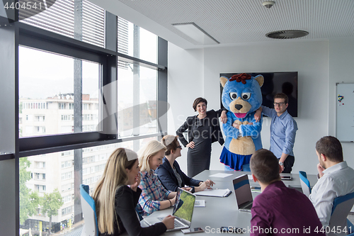 Image of boss dresed as bear having fun with business people in trendy of