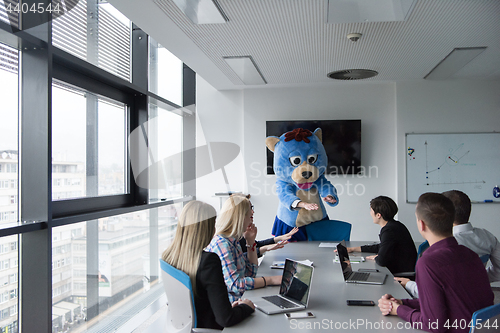 Image of boss dresed as bear having fun with business people in trendy of