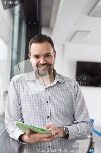 Image of Businessman Using Tablet In Office Building by window