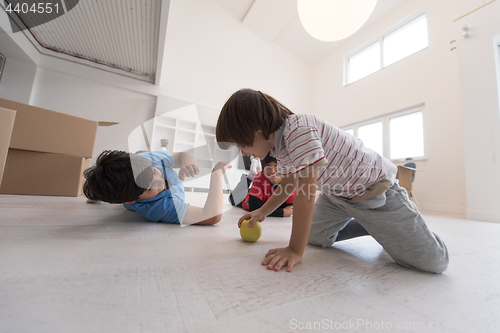 Image of boys having fun with an apple on the floor