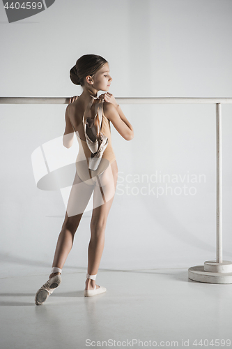 Image of The girl is training near the ballet barre.