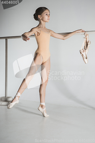 Image of The girl is training near the ballet barre.