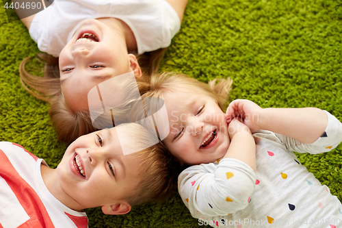 Image of happy little kids lying on floor or carpet