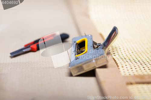 Image of staple gun and cutter knife with furniture item