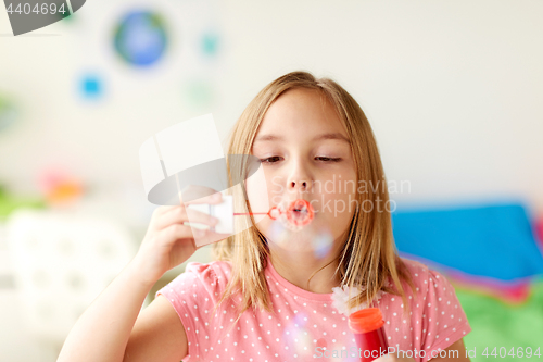 Image of girl blowing soap bubbles indoors