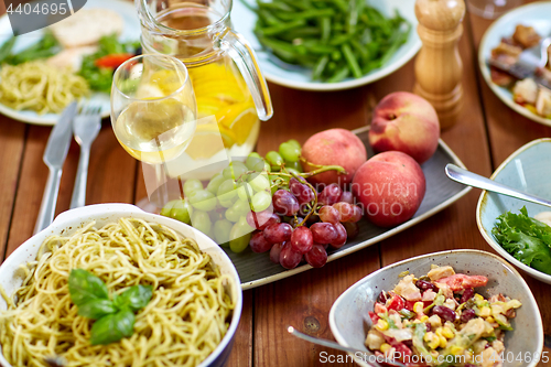 Image of fruits, salads and pasta on wooden table