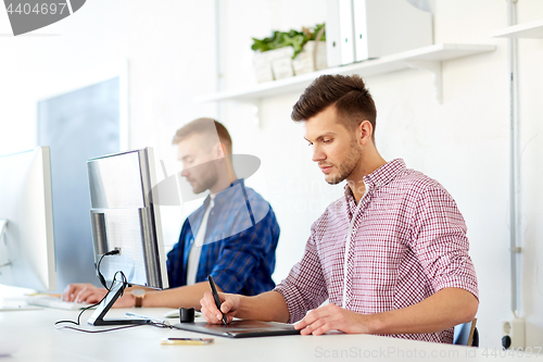 Image of designer with computer and pen tablet at office