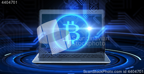 Image of laptop computer with bitcoin hologram