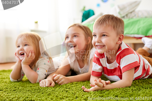 Image of happy little kids lying on floor or carpet