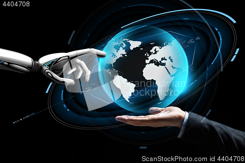 Image of human and robot hand with virtual earth hologram