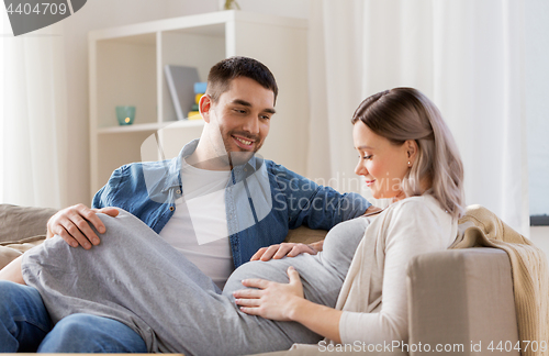 Image of happy man with pregnant woman at home