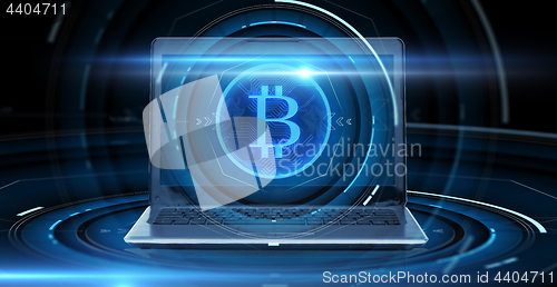 Image of laptop computer with bitcoin hologram