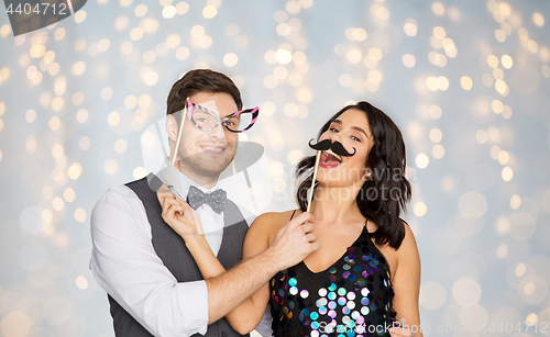 Image of happy couple with party props having fun