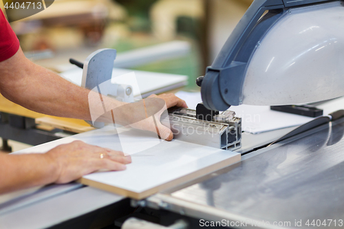 Image of carpenter with panel saw and fibreboard at factory