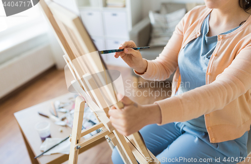 Image of artist with brush painting at art studio