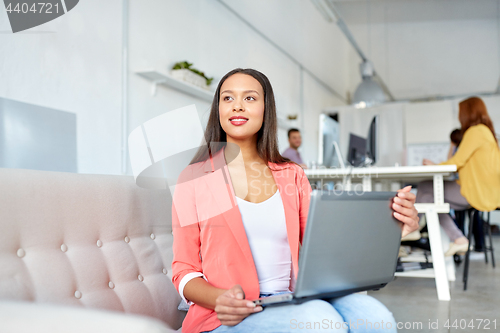 Image of happy woman with laptop working at office