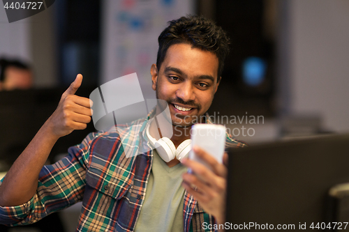 Image of man with smartphone having video call at office