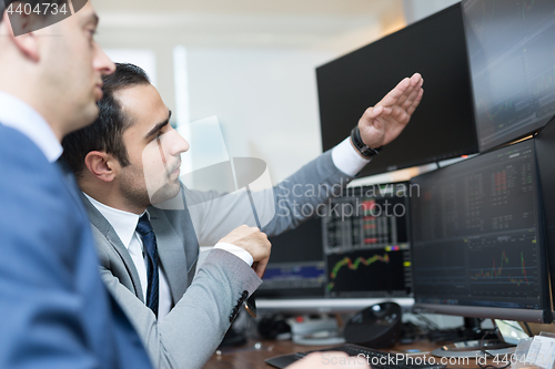 Image of Stock brokers looking at computer screens, trading online.