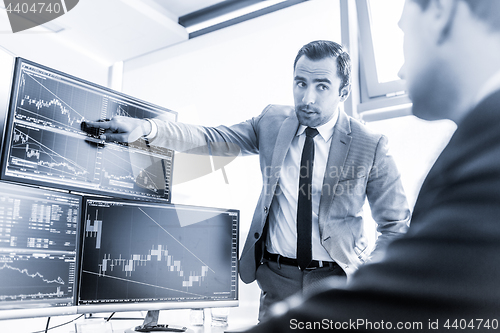 Image of Stock brokers trading online in corporate office.