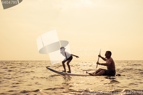 Image of Father and son  playing on the beach at the day time.