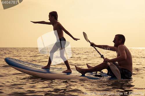 Image of Father and son  playing on the beach at the day time.