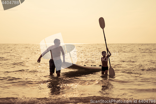 Image of Father and son  playing on the beach at the day time.