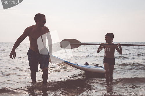 Image of Father and son  playing on the beach at the day time.