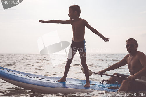 Image of Father and son  playing on the beach at the day time.