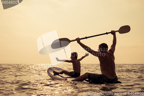 Image of Father and son  playing on the beach at the day time.