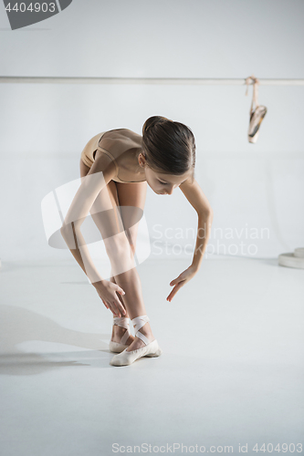 Image of The girl is training near the ballet barre.