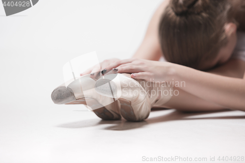 Image of Ballerina dancer sitting down with her legs crossed